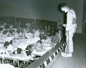 Photograph of patients on gurneys watching a performance of the Florida State University Circus in the Roosevelt Hall Auditorium at the  Georgia Warm Springs Foundation, Warm Springs, Meriwether County, Georgia, 1961. Roosevelt Warm Springs/Georgia Warm Springs Foundation Photograph Collection, Roosevelt Warm Springs Institute for Rehabilitation, Warm  Springs, Georgia.