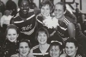Photograph from the 1995 University of North Georgia Cyclops yearbook. It is a black-and white photograph of a group of female cheerleaders, in their uniforms, standing in an informal group portrait.