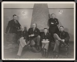 A photograph of six officers, taken at the United States Eighth Air Force unit headquarters at High Wycombe, England. 